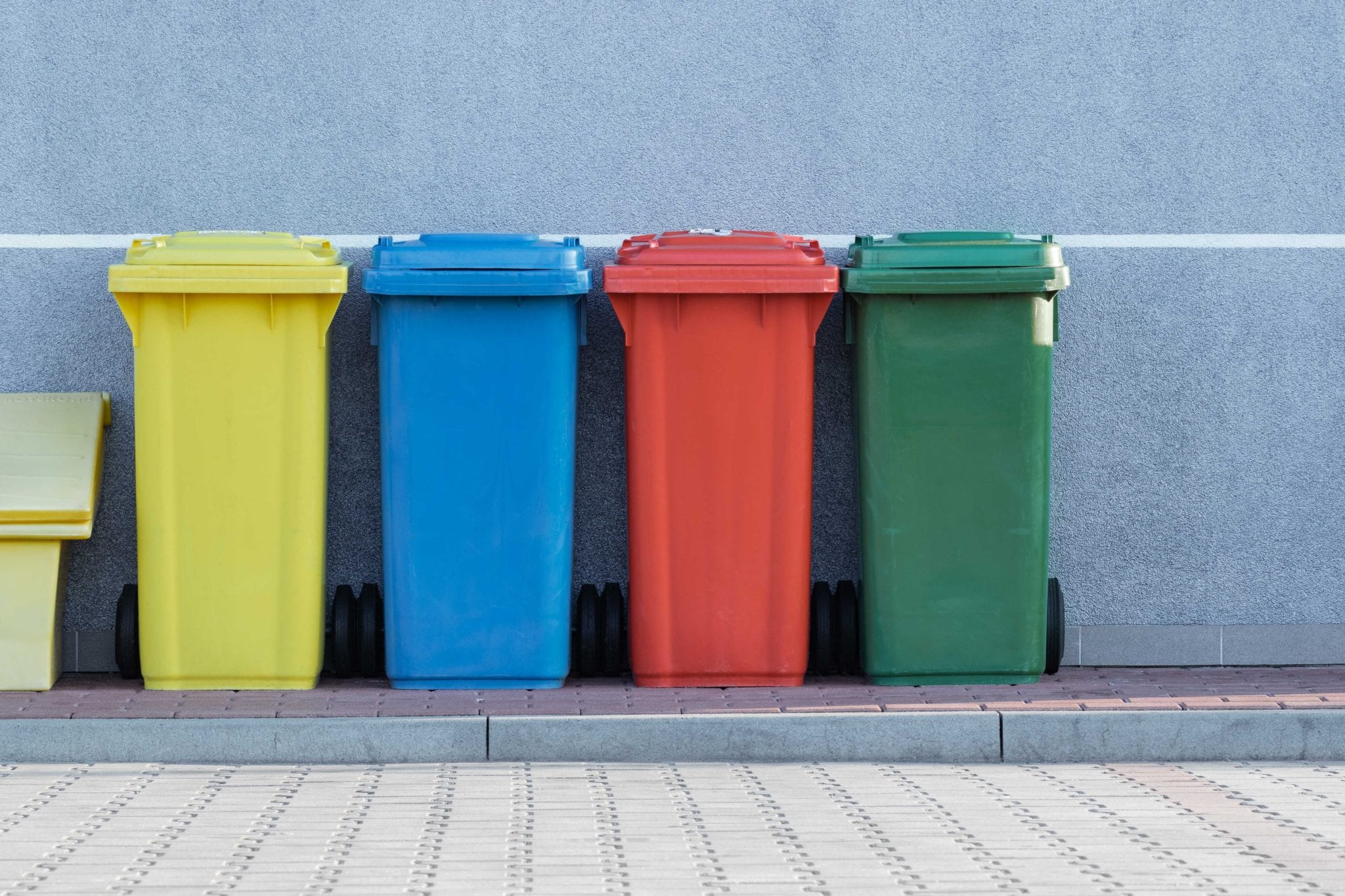 image of four trash cans, yellow, blue, red, and green