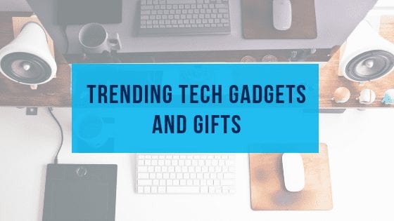 Photo of a desk with computer and accessories laid out and the text "trending tech gadgets and gifts"