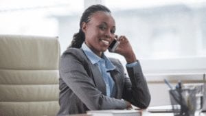 woman in suit sitting and making a call