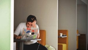 Man working on laptop in public space
